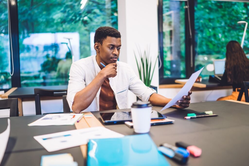 Black freelancer reading document and thinking